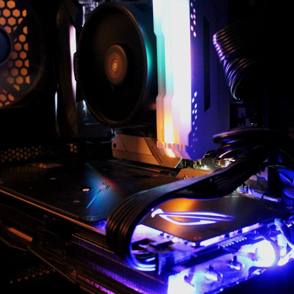 The inside of a computer with light up components, showing it's graphics card, RAM, and CPU on the motherboard.